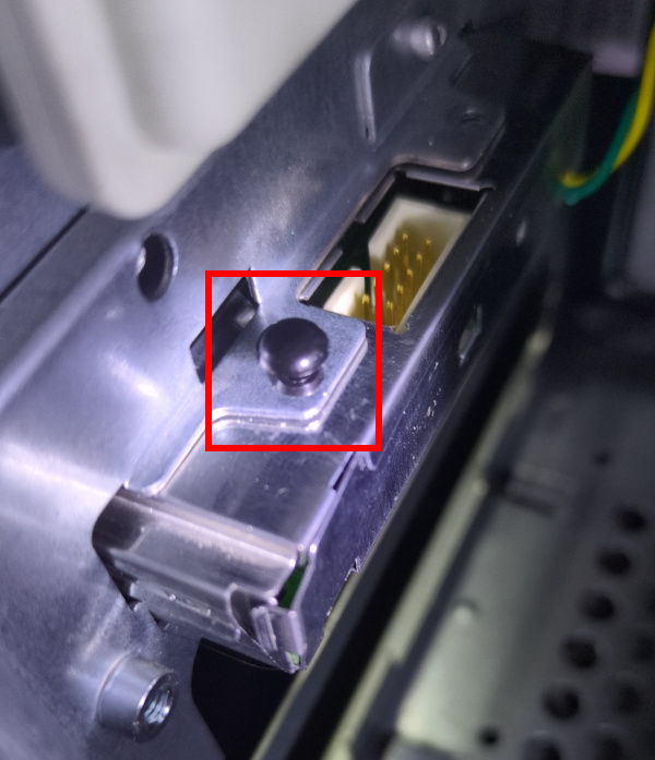 Plastic rivet standing partially out of the rear of the power board box inside of the PC.