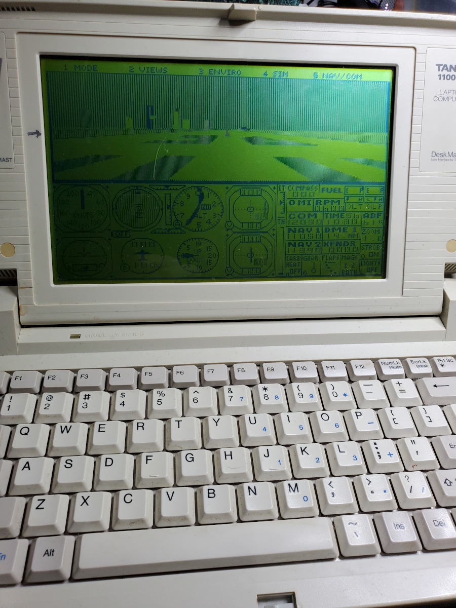 Tandy 1100FD displaying the Flight Simulator 4 simulation screen, sitting on the runway.