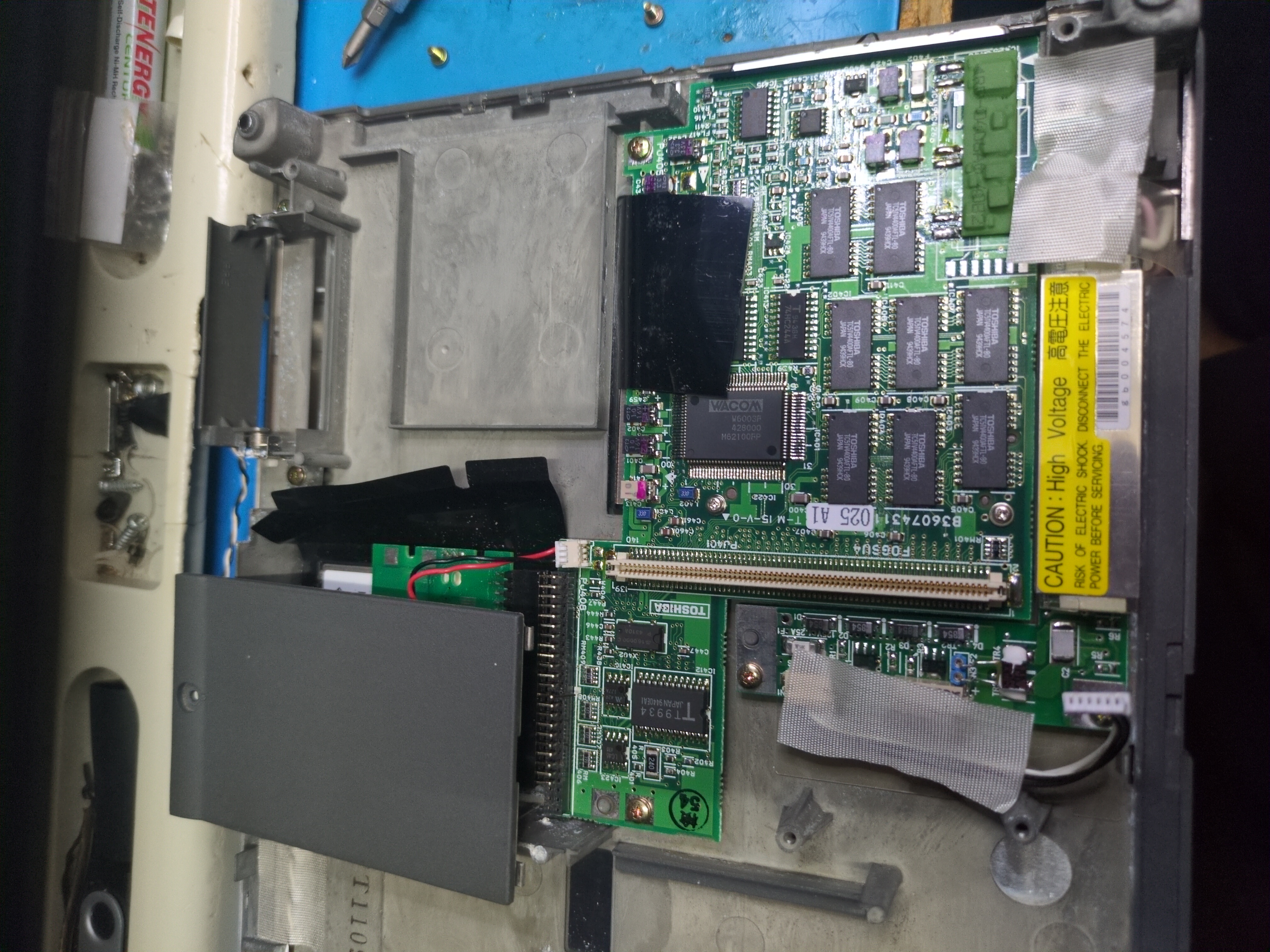 Photograph of a computer circuit board attached to the rear of the display inside of the tablet chassis. A chip with the marking 
